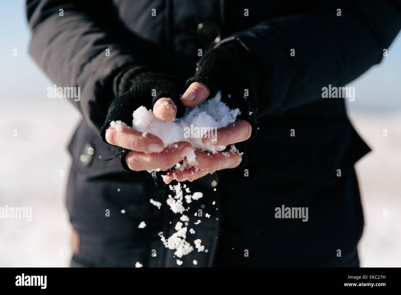 Donna che mantiene la neve in mani Foto Stock