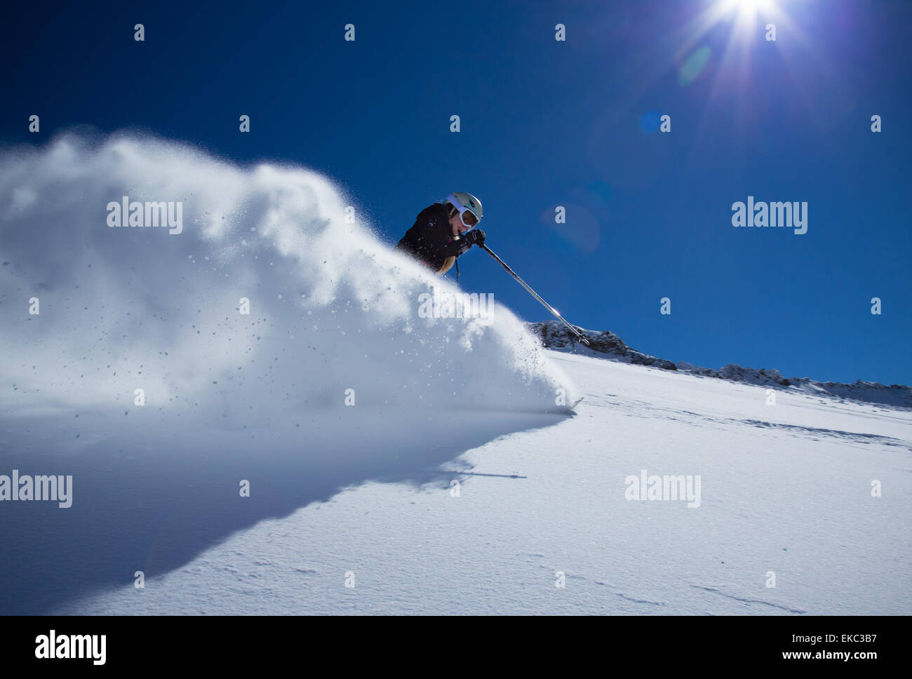 Snowboarder in alta montagna durante la giornata di sole. Foto Stock