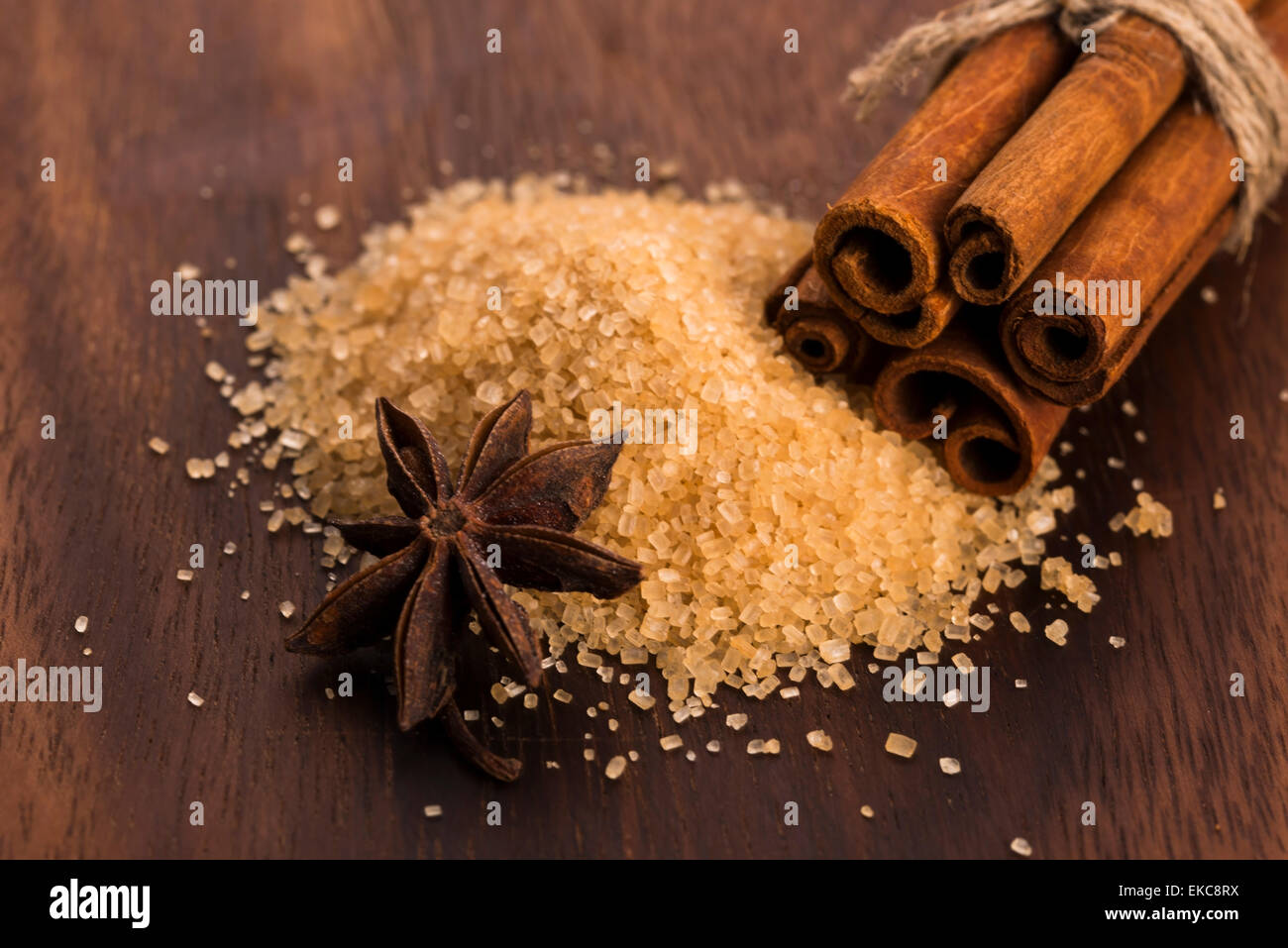 Bastoncini di cannella con puro di canna da zucchero marrone su uno sfondo di legno Foto Stock