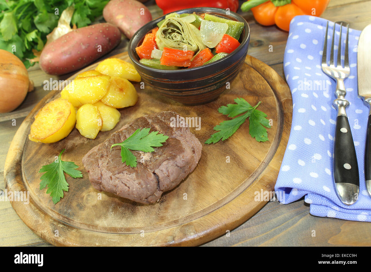 Arrosto bistecche di carne di struzzo con patate al forno e prezzemolo su una tavola di legno Foto Stock