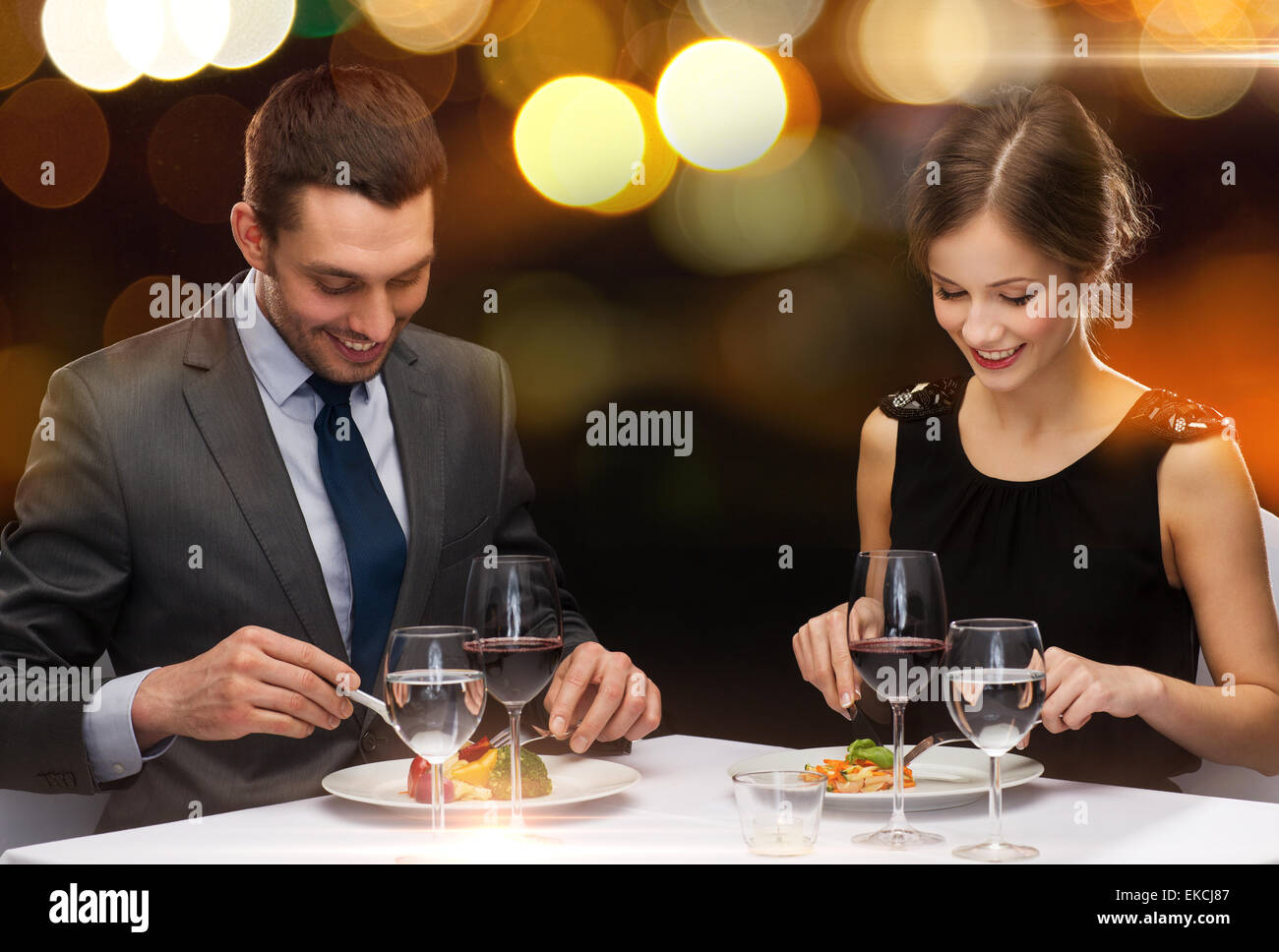 Sorridente giovane mangiare corso principale presso il ristorante Foto Stock