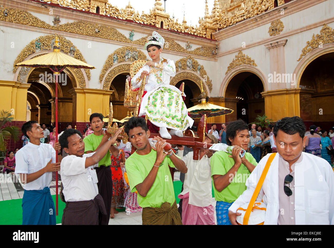 I bambini e le loro famiglie parade di vistosi bejeweled costumi in loro venuta di età cerimonia in Myanmar Mandalay Foto Stock