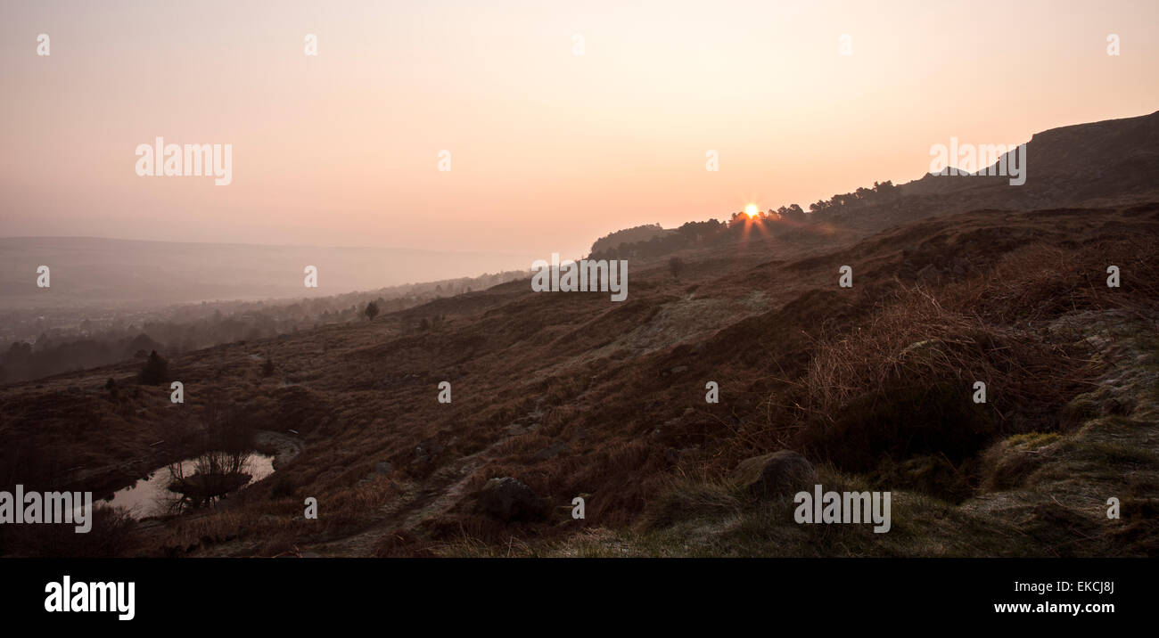 Tramonto su alberi e tarn superiore a Ilkley Moor Yorkshire da pozzetti bianchi Foto Stock