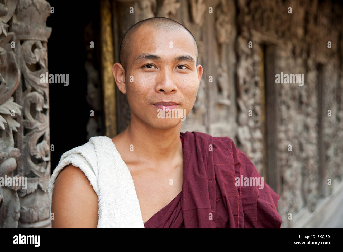 Questo Monaco si trova di fronte il teak intagliato parete del Shwenandaw Kyaung Pagoda in Mandalay MYANMAR Birmania Foto Stock