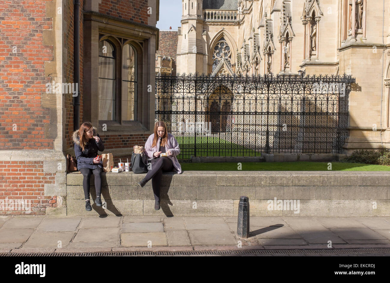 Due giovani donne prendendo un al fresco della pausa pranzo presso il St John's College di Cambridge Cambridgeshire England Foto Stock