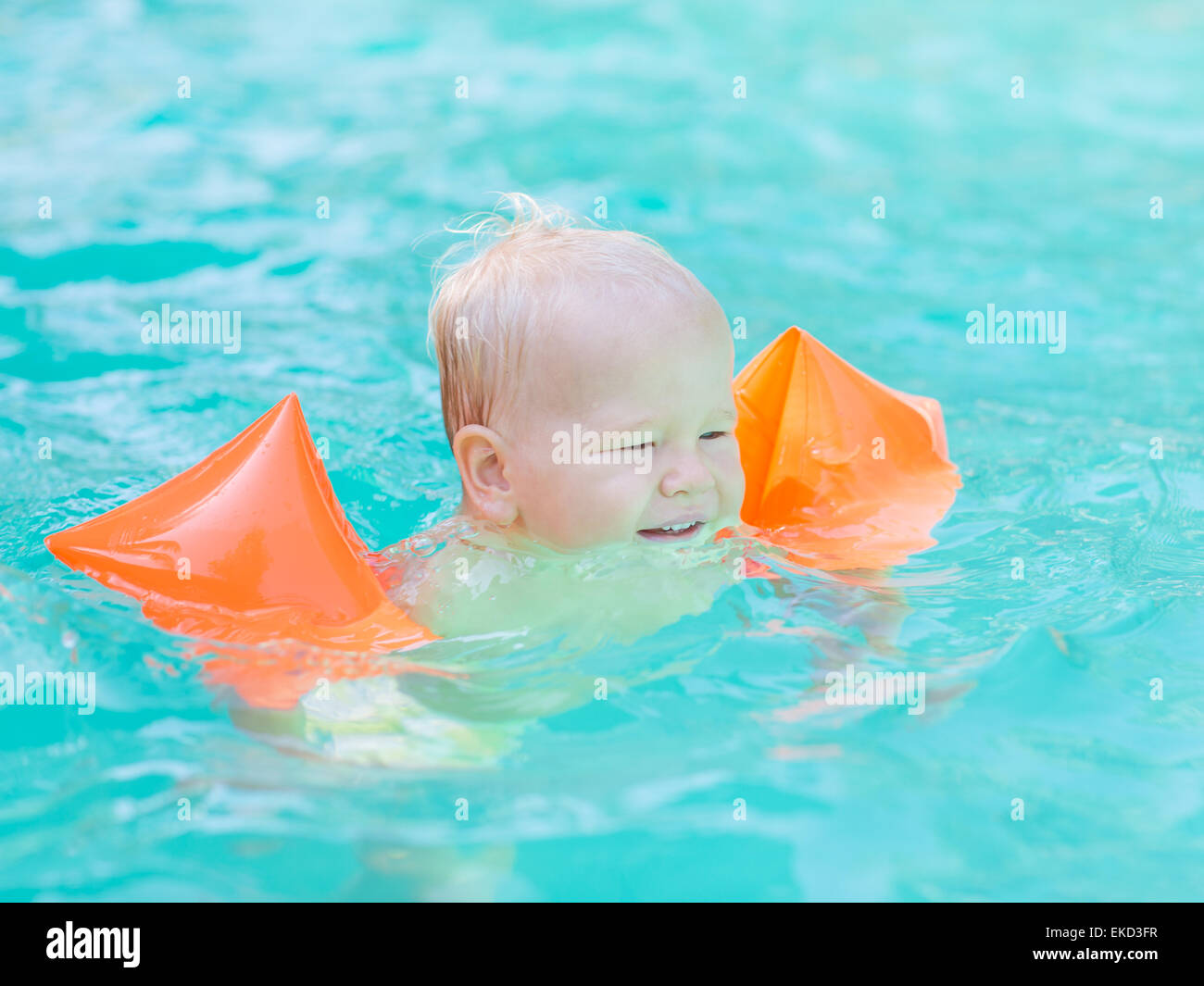 Bambino con fasce da braccio in piscina Foto stock - Alamy
