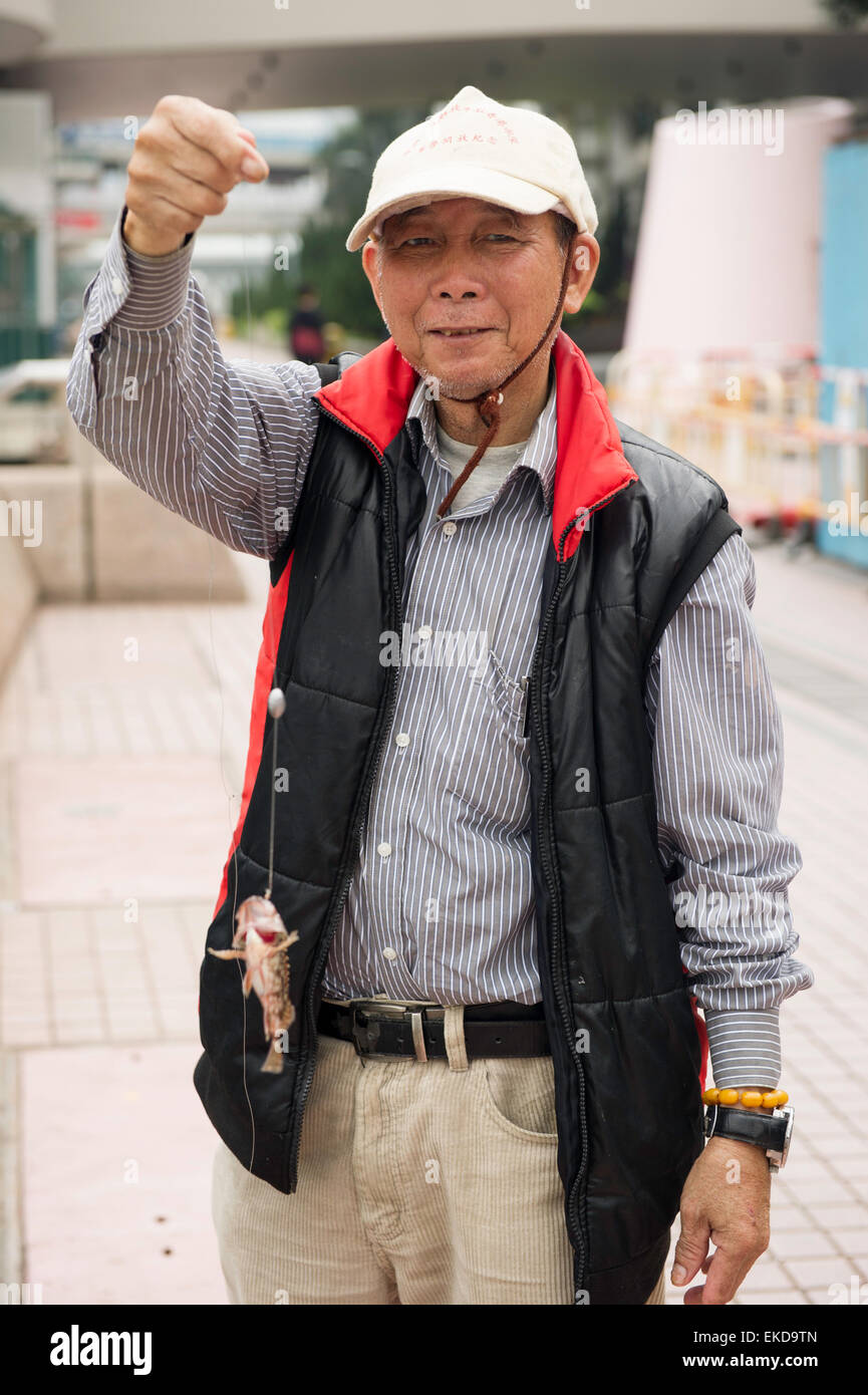 Hong Kong pescatore con pesce. Foto Stock