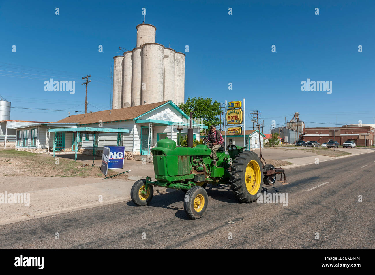 Vecchio contadino alla guida di un trattore verde. Tulia. Texas Panhandle. Stati Uniti d'America Foto Stock