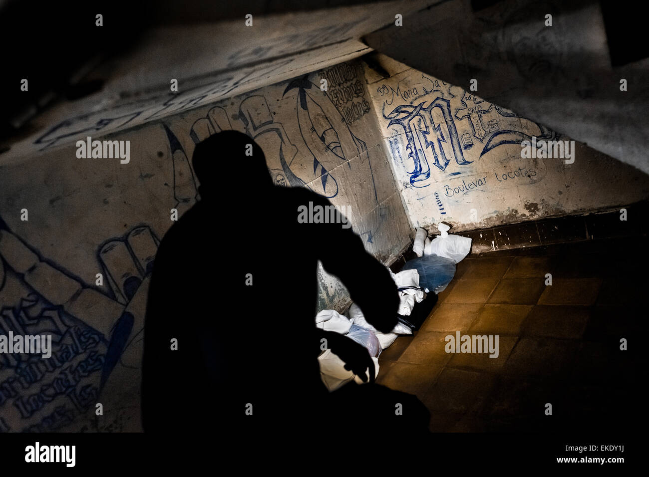 Una guardia carceraria le ricerche per il traffico della droga e delle armi in un Mara gang membri cella al centro di detenzione in El Salvador. Foto Stock