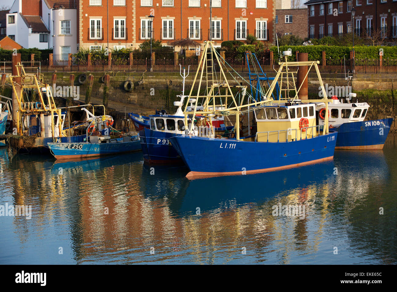 Dipinta di fresco pesca barca ormeggiata in la campanatura Docks old Portsmouth. La riflessione su una abbastanza calma giorno può essere visto. Foto Stock
