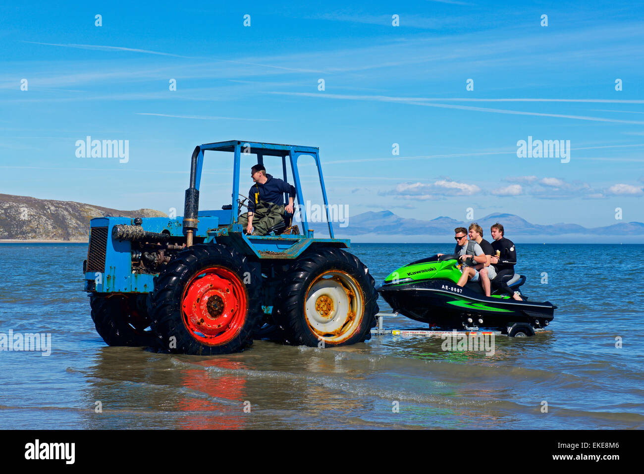 Tre ragazzi su jetski trainato fuori del mare dal trattore, Abersoch, Gwynedd, North Wales UK Foto Stock