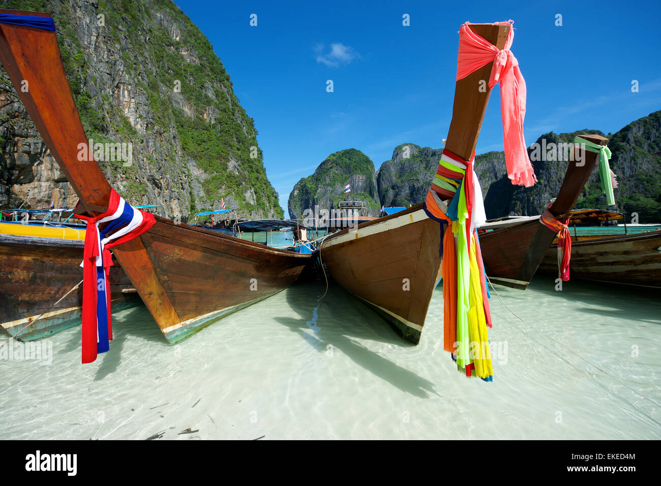 Tradizionale in legno tailandese longtail barche con anta decorativo nastri a Maya Bay in Koh Phi Phi Leh Island Foto Stock