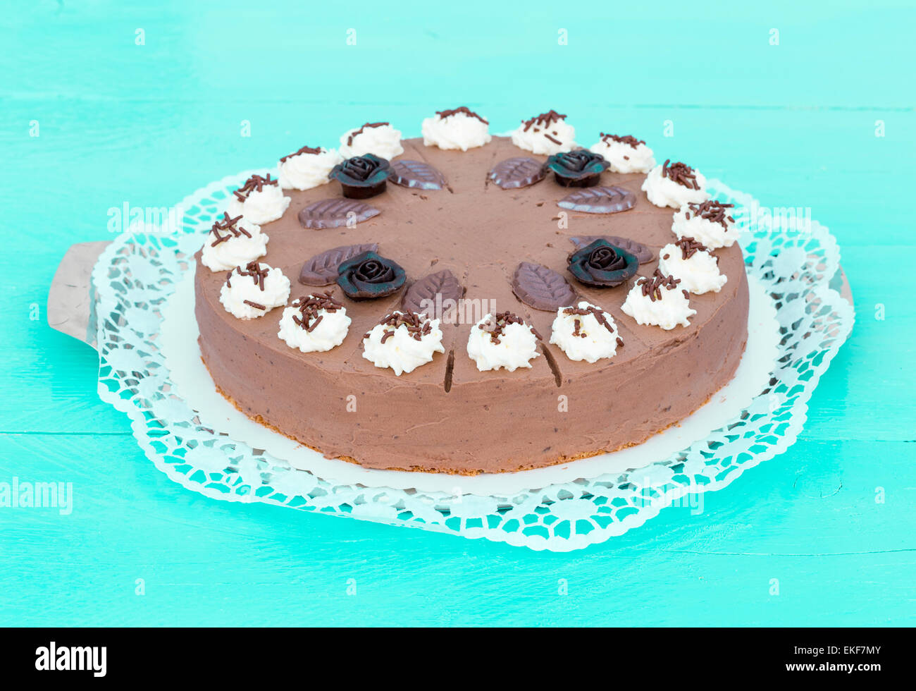 Crema di cioccolato torta su legno color turchese con torta di pizzo. Foto Stock