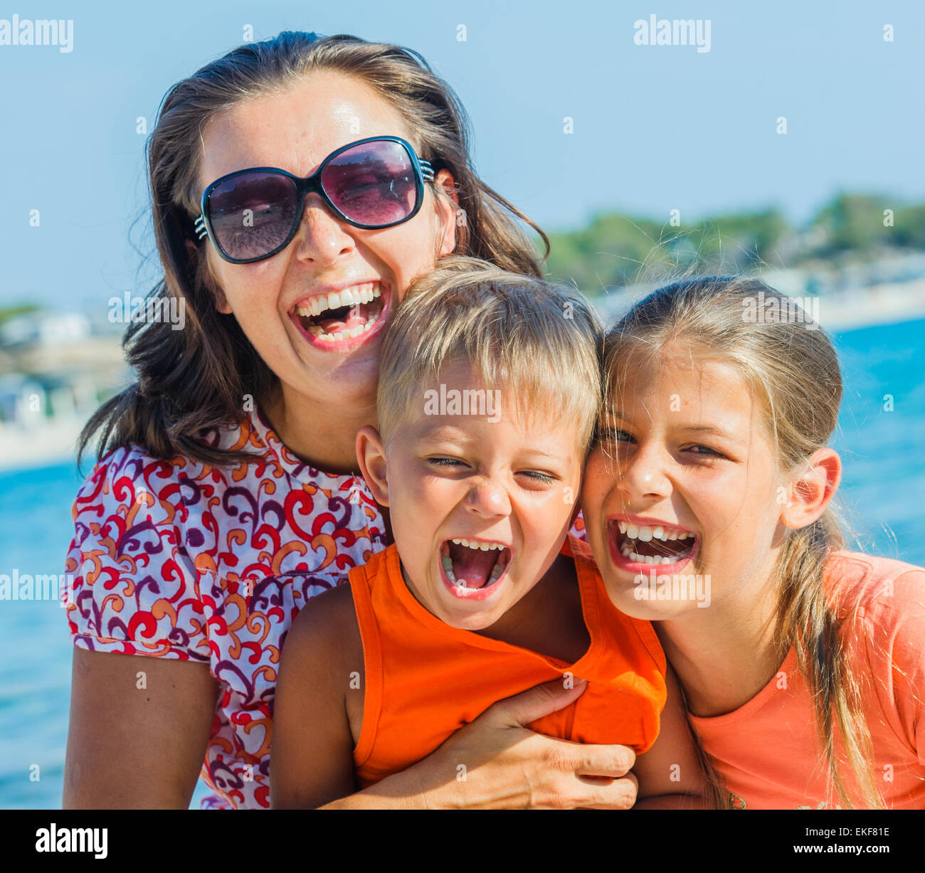 Foto di famiglia felice sulla spiaggia Foto Stock
