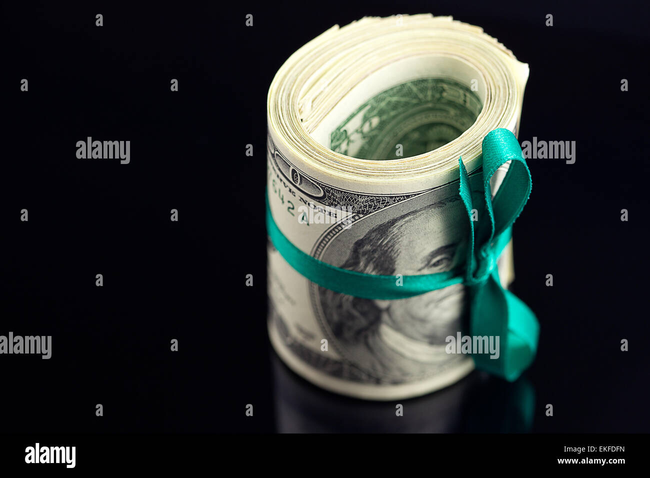 Di dollari arrotolato in un tubo su sfondo nero Foto Stock