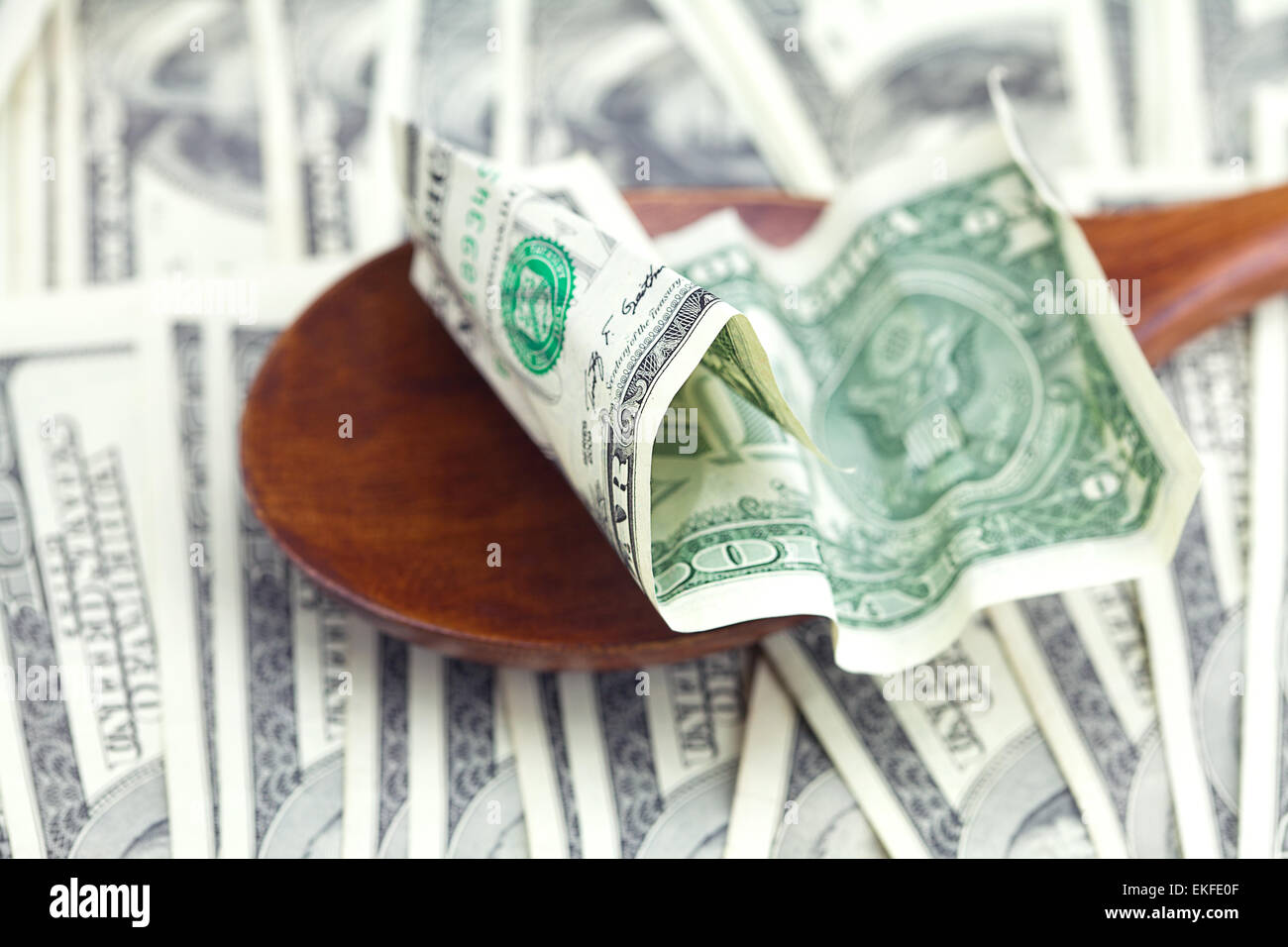 In dollari il cucchiaio di legno su sfondo di dollari Foto Stock