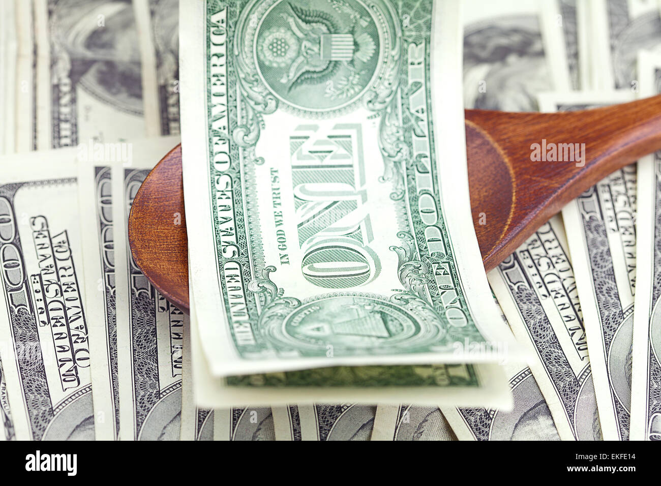 In dollari il cucchiaio di legno su sfondo di dollari Foto Stock