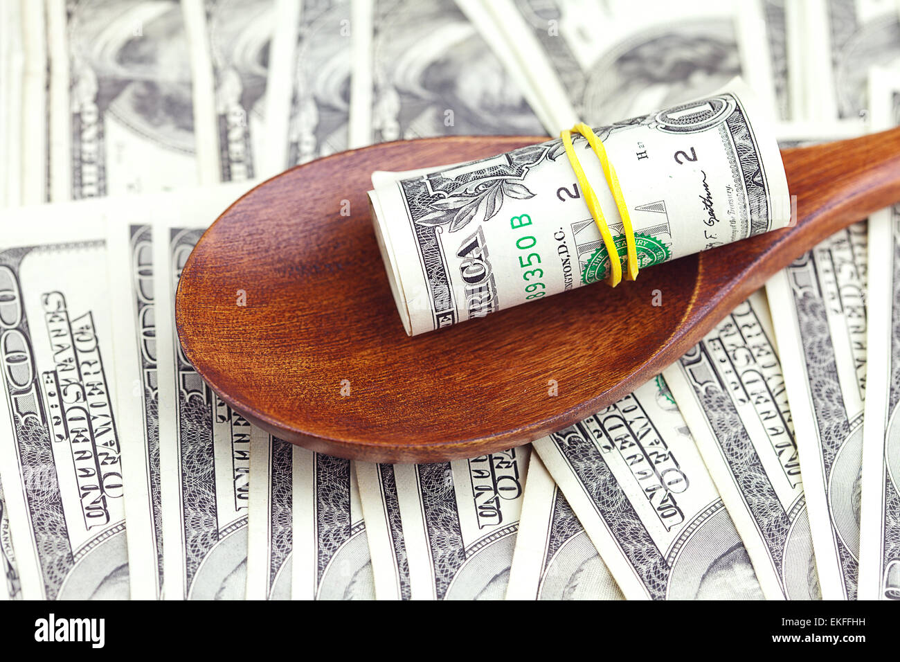In dollari il cucchiaio di legno su sfondo di dollari Foto Stock