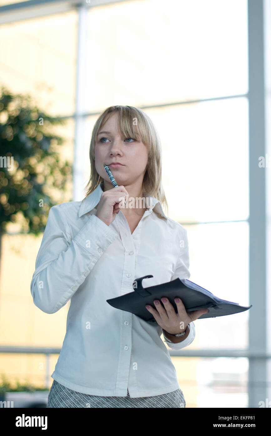 Giovane imprenditrice con il pianificatore di giorno nella lobby Foto Stock