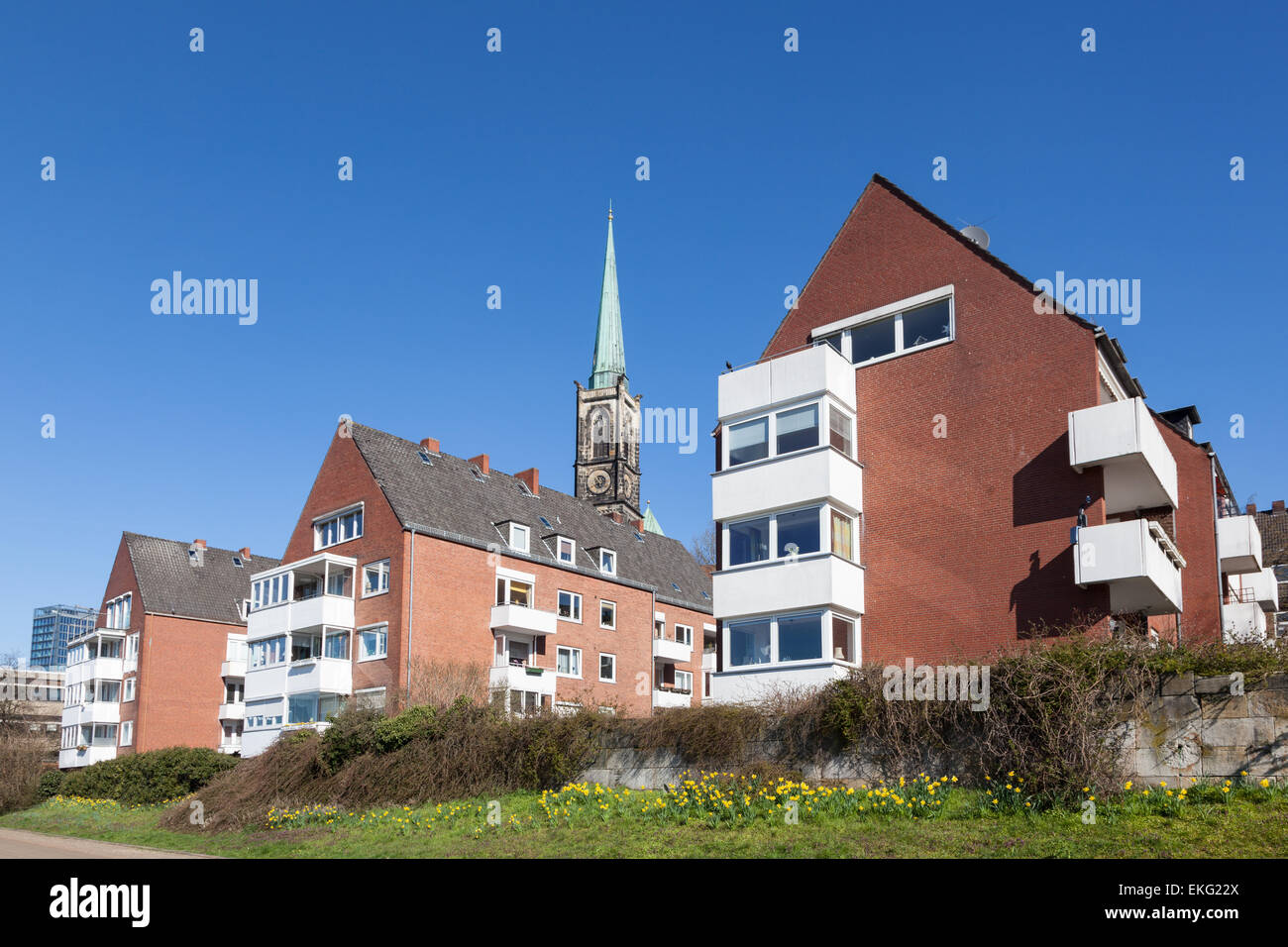 Red case in mattoni con una chiesa in background in Bremen, Germania Foto Stock