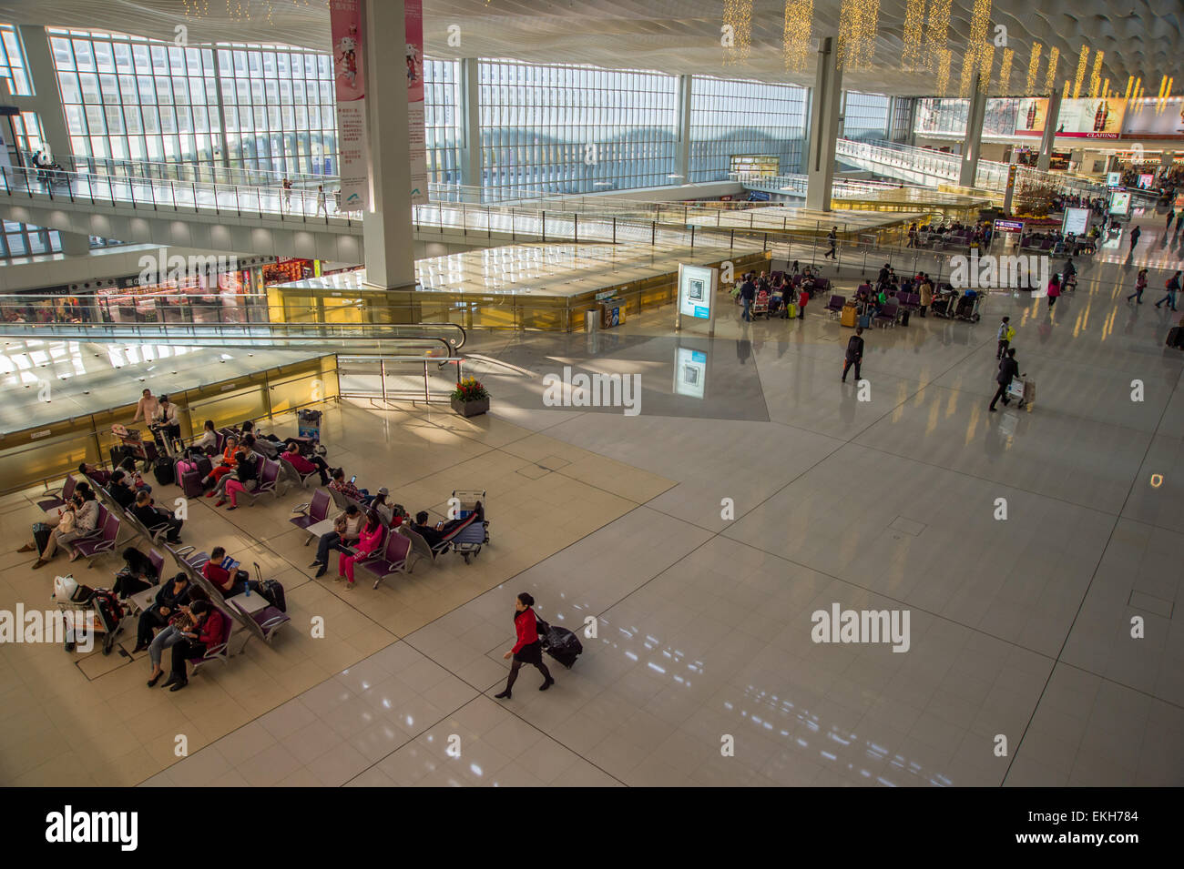 I passeggeri in attesa per i loro voli a Hong Kong Airport Foto Stock
