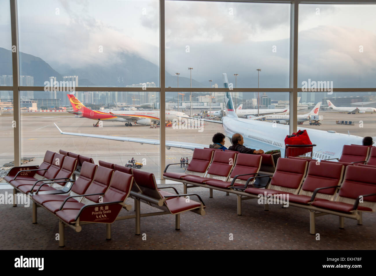 I passeggeri in attesa per i loro voli a Hong Kong Airport Foto Stock
