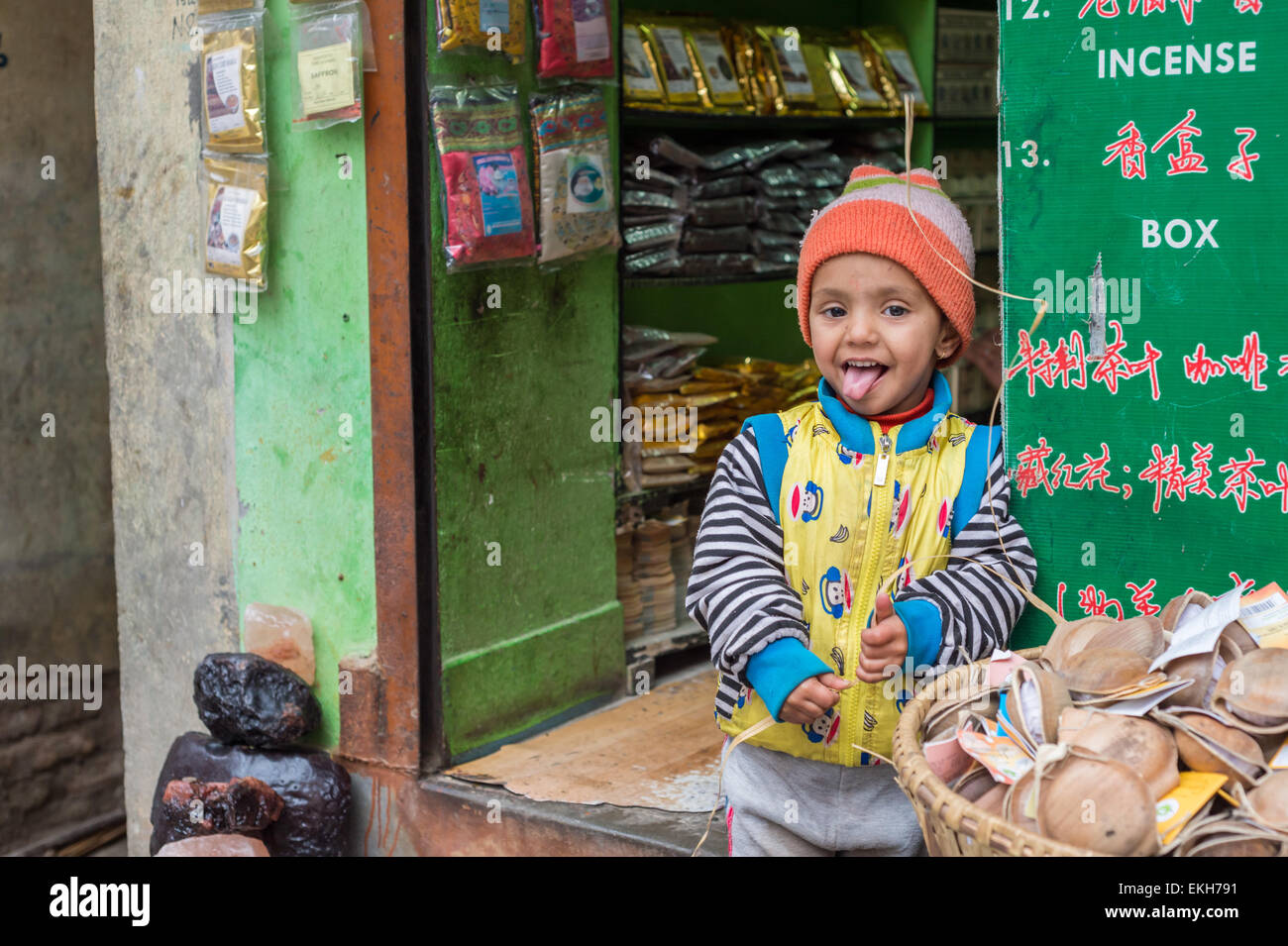 Ragazzo nepalese di fronte a un negozio di incenso di Kathmandu Foto Stock