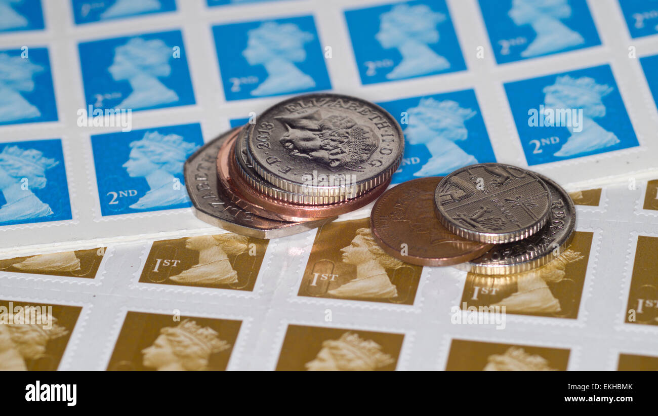 Regno Unito di prima e seconda classe di francobolli, con monete. Foto Stock