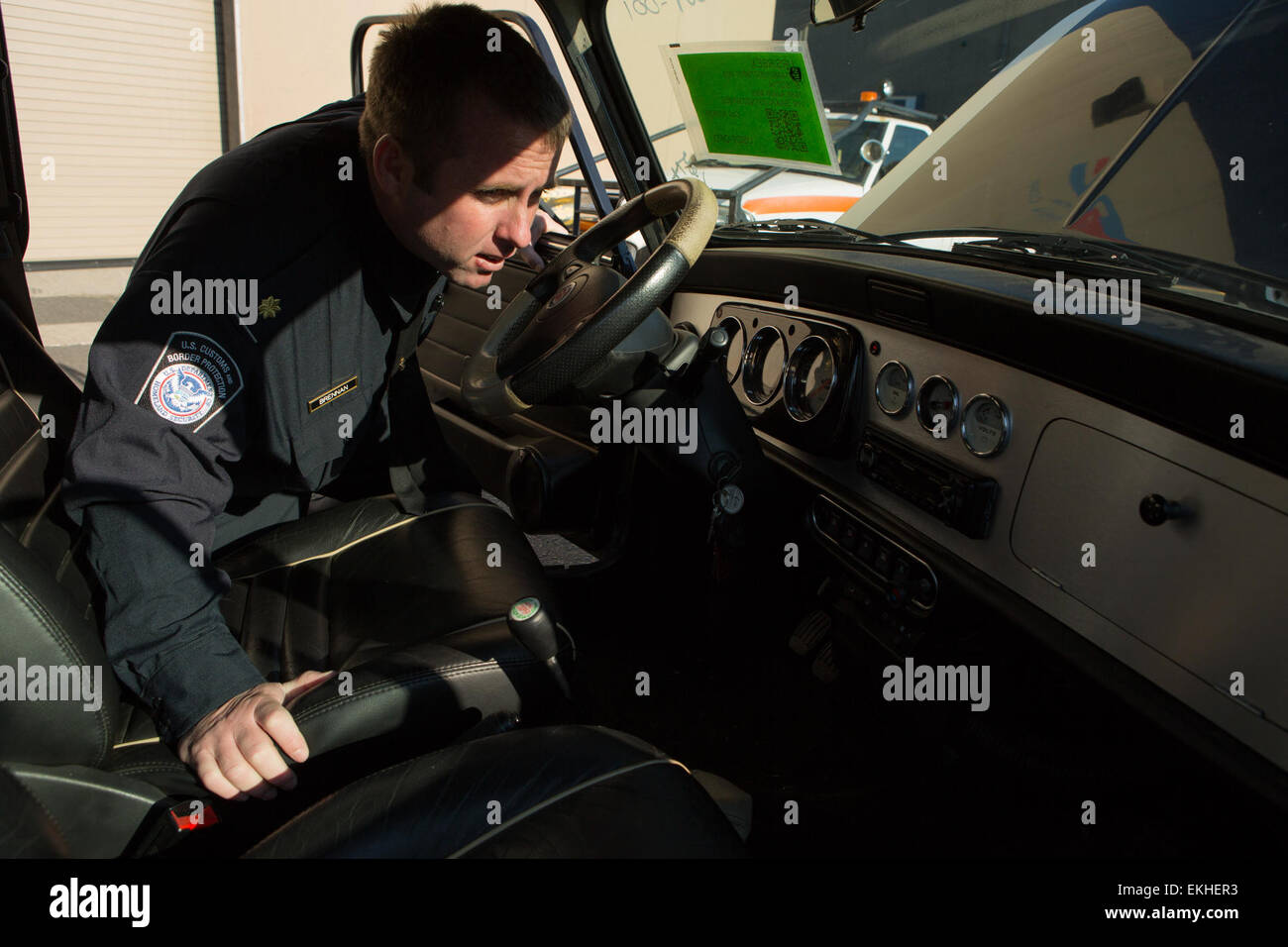 Un Customs and Border Protection Officer ispeziona una Mini Cooper che sono arrivati a Port Elizabeth NJ che aveva numerose violazioni ad esso associato per l'importazione. Questo veicolo sarà distrutto come risultato. Foto di James Tourtellotte Foto Stock