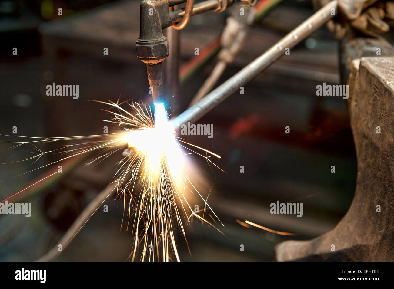 Un costruttore di metallo utilizzando una torcia a calore di un pezzo di metallo per dare forma a. Foto Stock