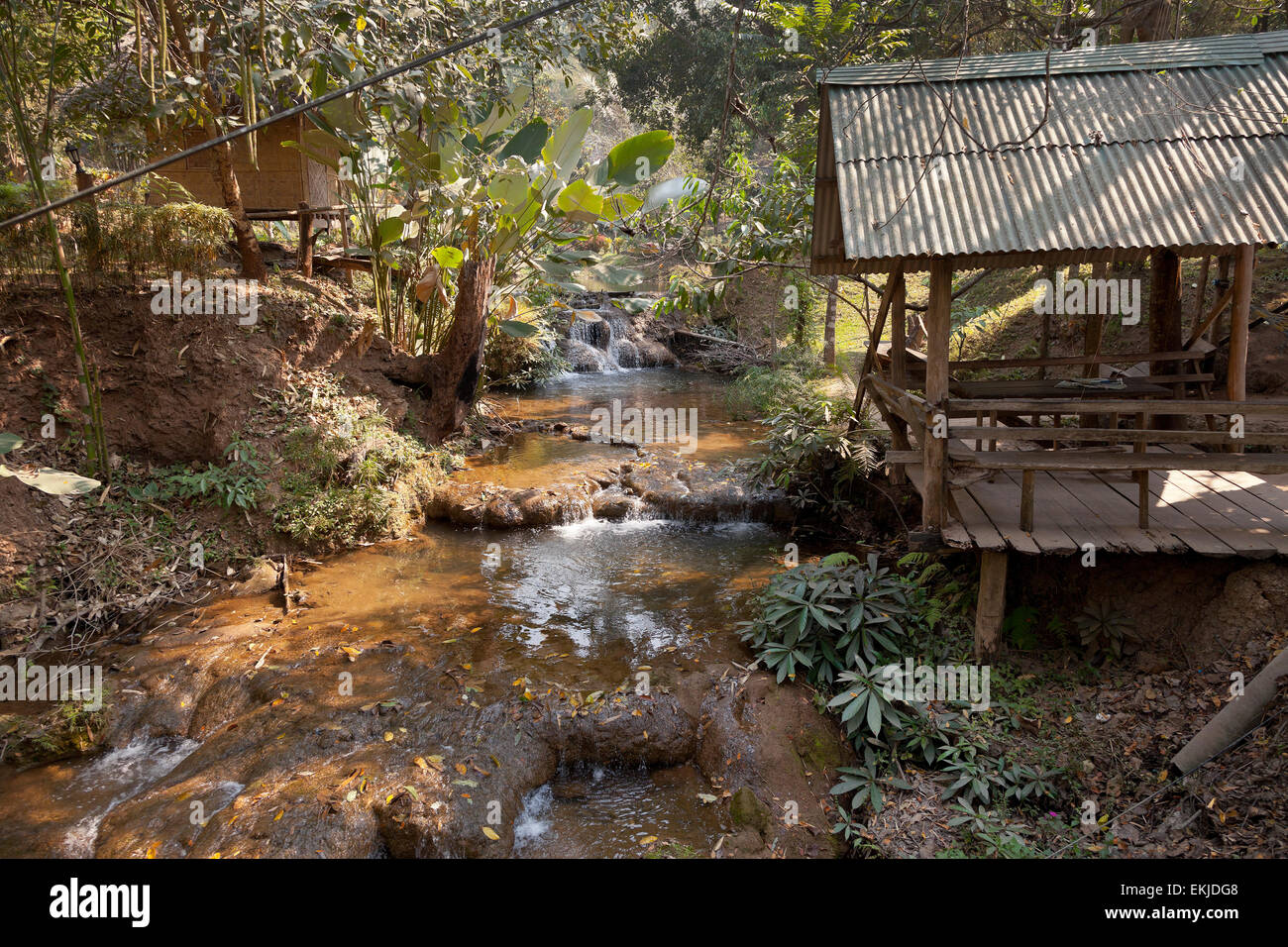 Insediamento Hilltribe, Thailandia del Nord, semplici baracche di legno da un torrente di montagna. Foto Stock