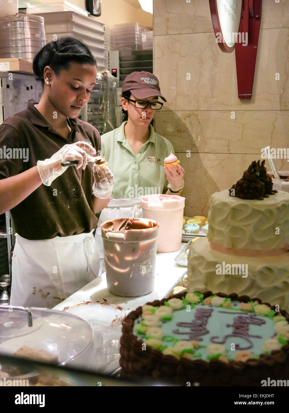 Lavoratori tortini di glassa, Magnolia panificio, Grand Central Terminal, NYC, STATI UNITI D'AMERICA Foto Stock