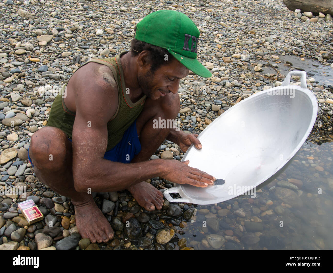 Jungle, Indonesia - 13 Gennaio 2015: un uomo della tribù Korowaya lavaggio oro utilizzando una ciotola Foto Stock