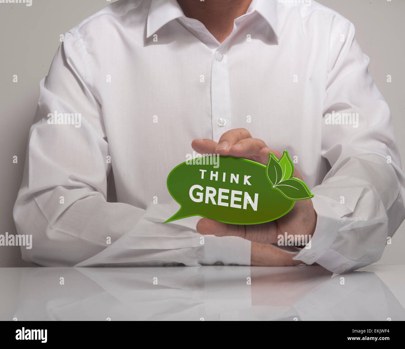 Immagine di un man mano che tiene il parlato palloncino con il verde textthink, camicia bianca. Concetto di ecologia e ambiente preservatio Foto Stock