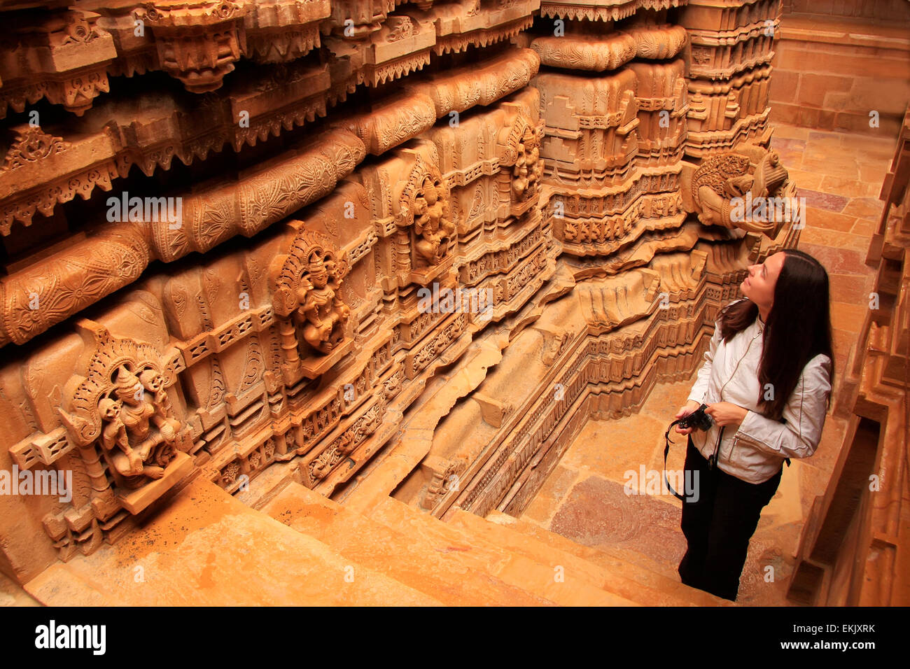 Giovane donna ammirando interno del tempio Jain, Jaisalmer, Rajasthan, India Foto Stock