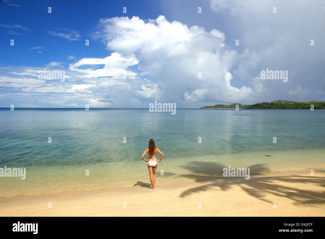 Giovane donna in bikini in piedi su una spiaggia tropicale, Nananu-i-Ra isola, Figi e Sud Pacifico Foto Stock