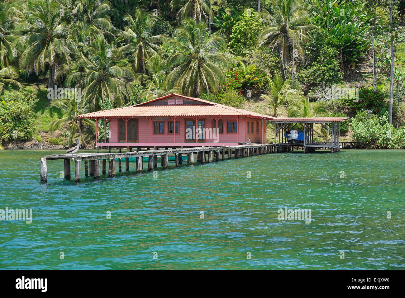 Casa dei caraibi con il dock sull'acqua e vegetazione tropicale sulla terraferma, Bocas del Toro, Panama America Centrale Foto Stock