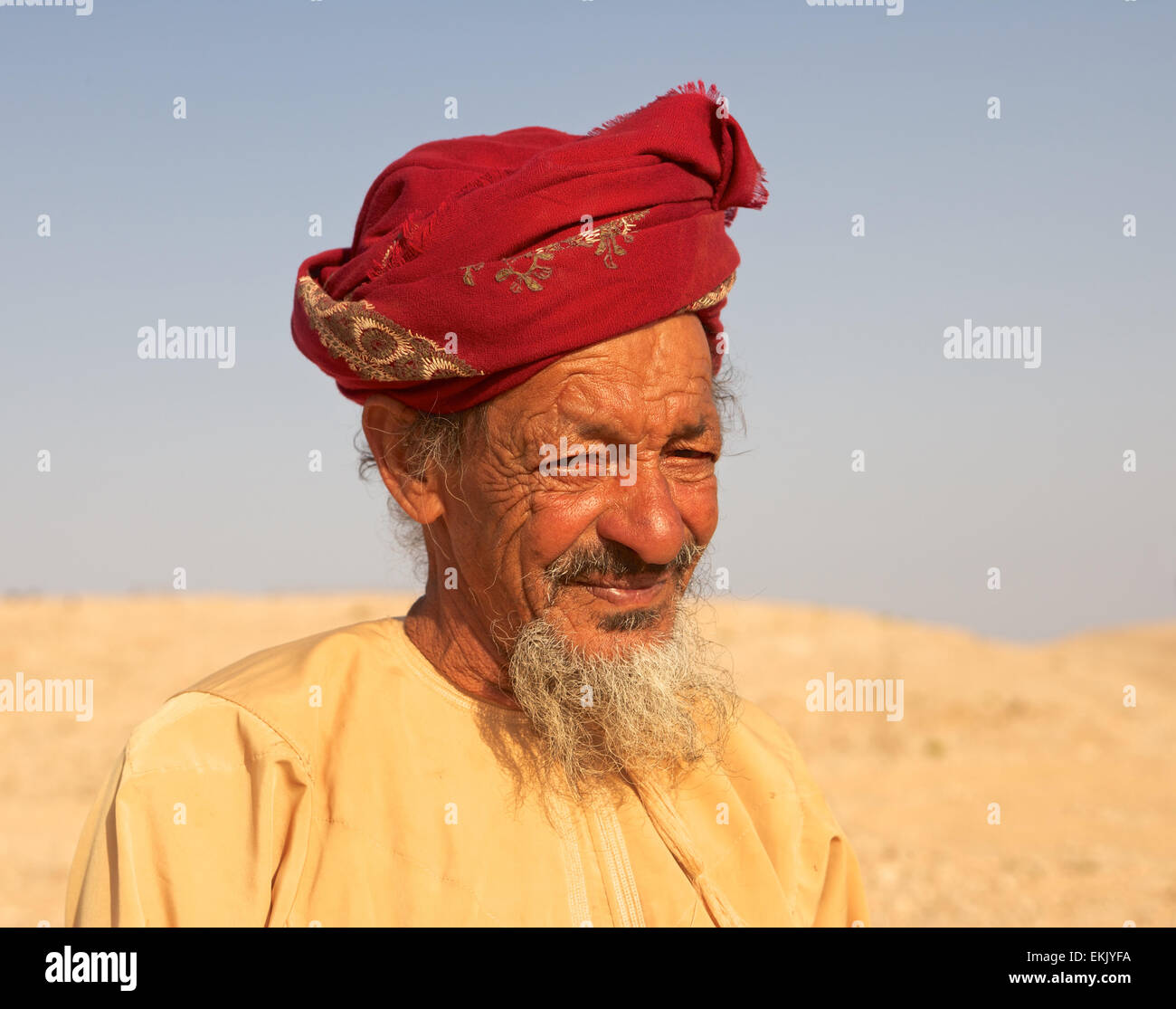 Un Omani non identificato agricoltore indossando un muzzar (tradizionale turbante di lana) indagini del suo paese nel deserto interno di Oman. Foto Stock