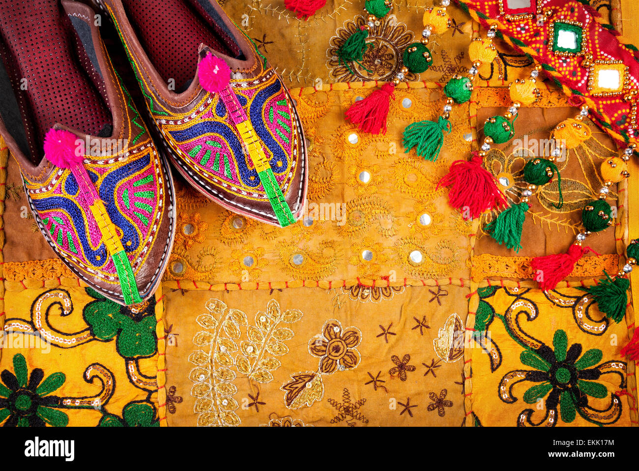 Colorate scarpe etniche e gipsy cintura gialla sul cuscino del Rajasthan coperchio sul mercato delle pulci in India Foto Stock