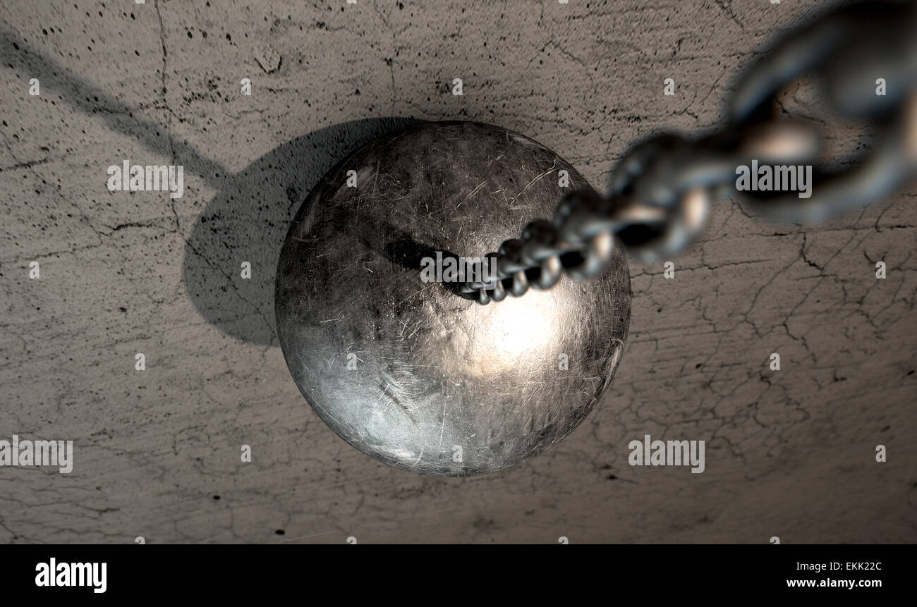 Un metallo regolari Wrecking Ball attaccato a una catena che colpisce una superficie di cemento Foto Stock