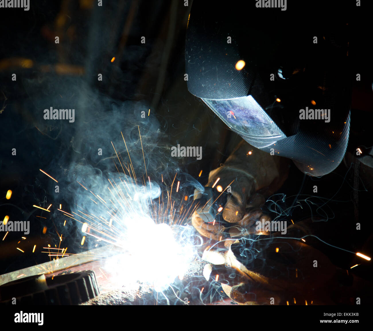 Saldatore in azione con scintille luminose. La costruzione e la fabbricazione di tema. Foto Stock