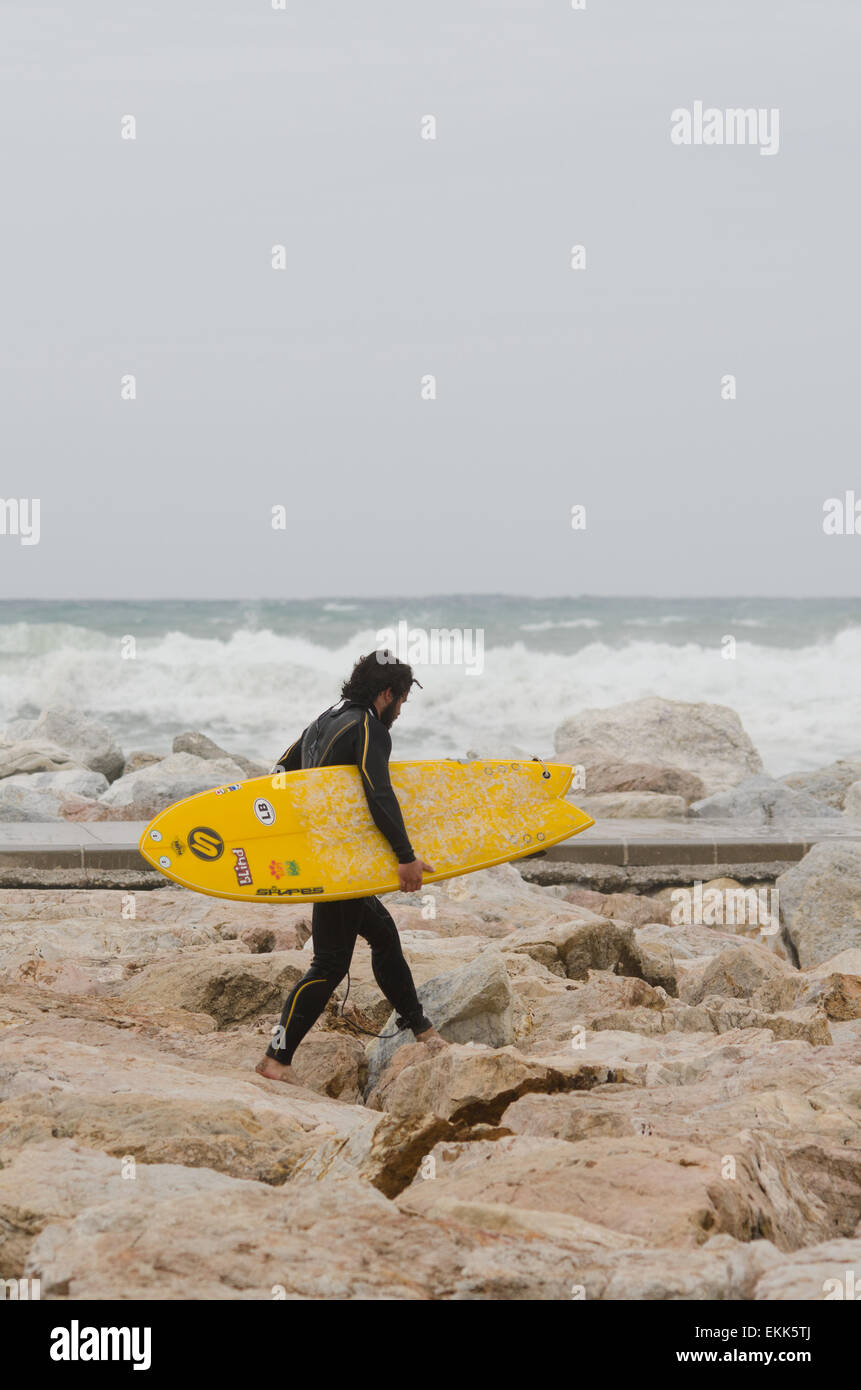 Stand-up Surfer a piedi con la tavola da surf lungo il molo, Andalusia, Spagna. Foto Stock