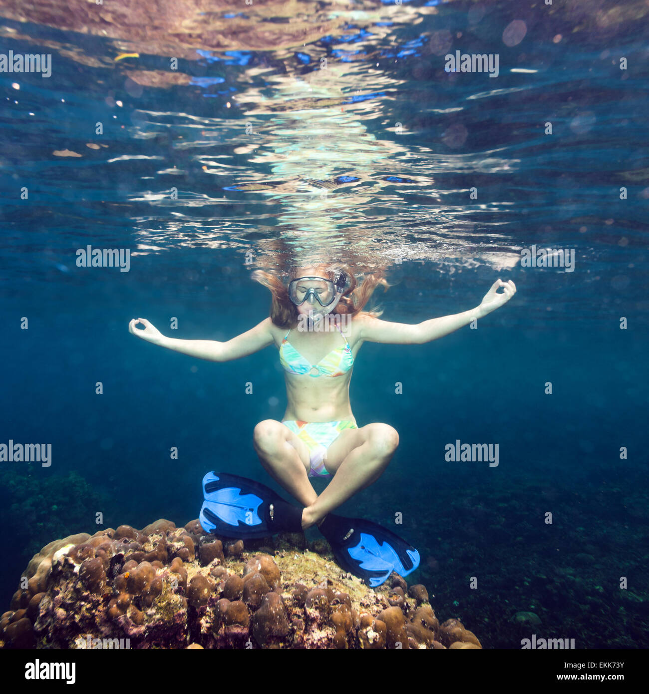 Giovane donna meditando sott'acqua al di sopra del corallo Foto Stock