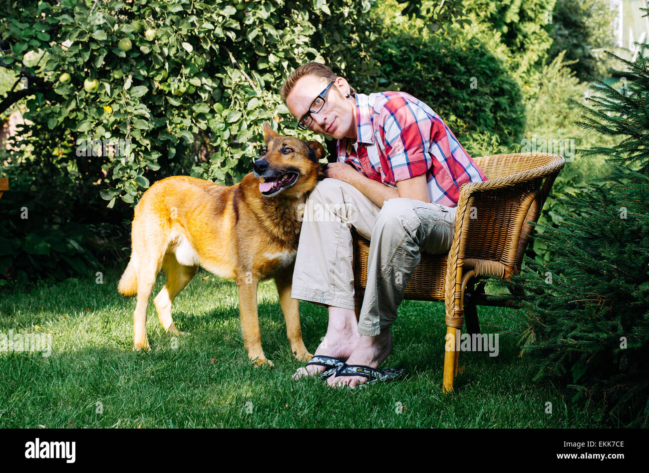 L uomo e il suo cane resto in giardino Foto Stock