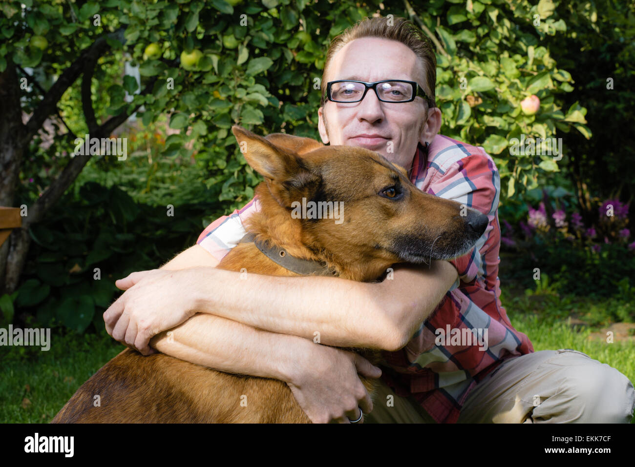 L uomo e il suo cane resto in giardino Foto Stock
