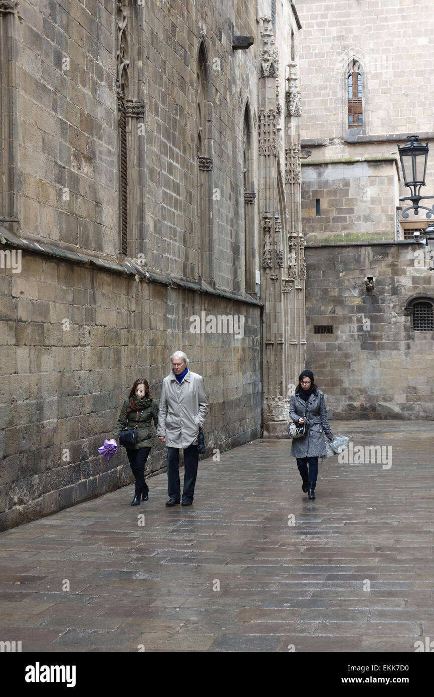 La gente camminare lungo la strada posteriore dietro la cattedrale sulla giornata piovosa a Barcellona Foto Stock