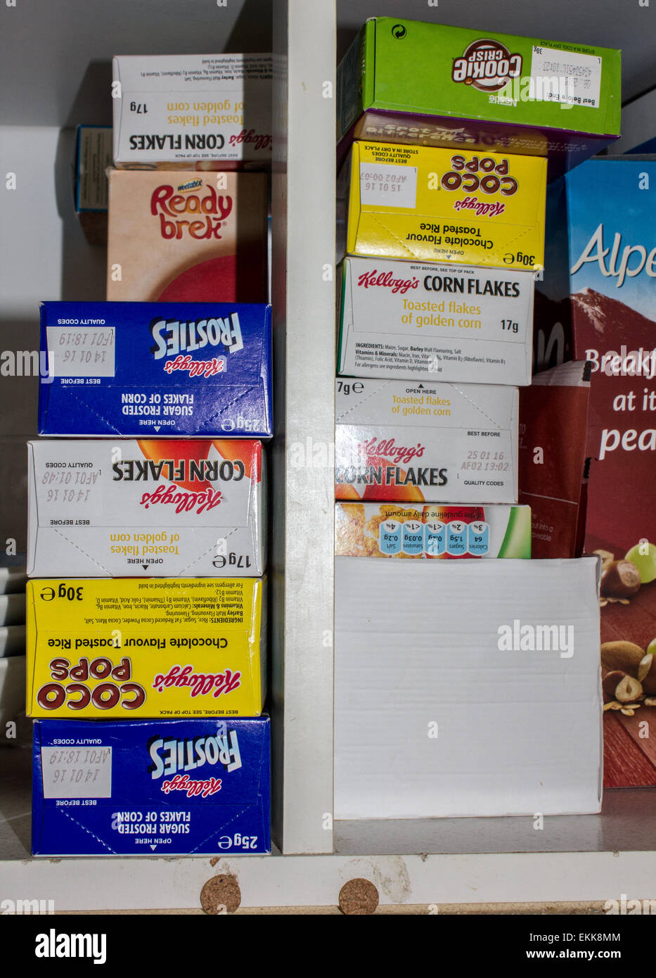 Mobili da cucina piena di mini pacchetti di cereali come pure dimensioni normali pacchetti di cereali. Foto Stock