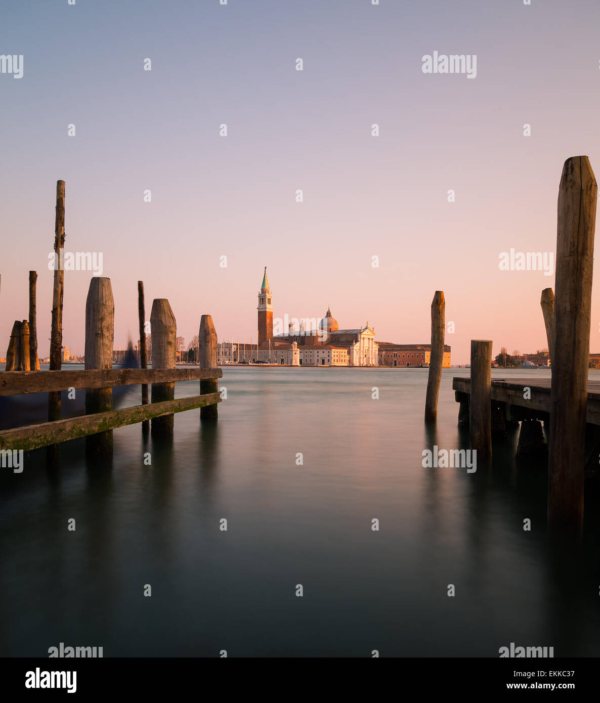 La Chiesa di San Giorgio Maggiore dal principale sul lungomare di Venezia che mostra posti di legno in primo piano Foto Stock