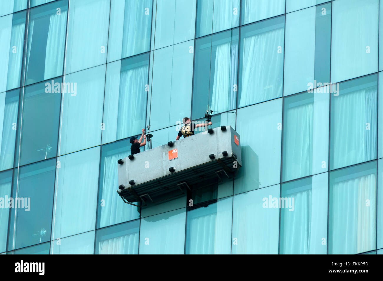 Detergenti per finestre sospese in una culla sul Beetham Tower, Deansgate, Manchester, Inghilterra, Regno Unito Foto Stock