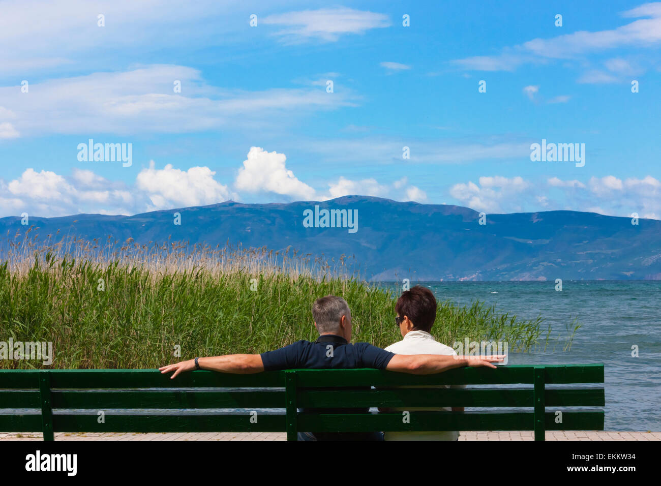 I turisti seduti su una panchina presso il lago di Ohrid, sito Patrimonio Mondiale dell'UNESCO, Repubblica di Macedonia Foto Stock